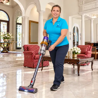 Rosani from iClean vacuuming a living room with red armchairs