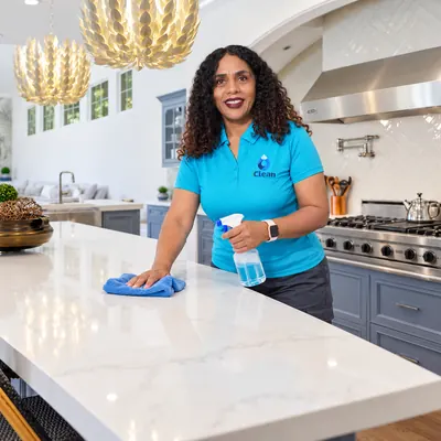 Telminha from iClean wiping down a marble kitchen island