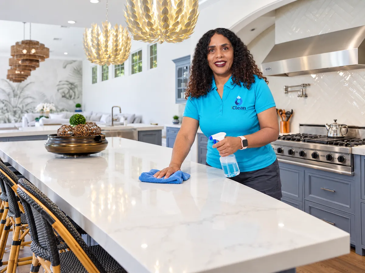 Telminha from iClean wiping down a marble kitchen island